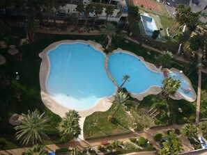 An aerial view of a resort with two large swimming pools surrounded by palm trees and greenery. - Gemelos 22 13c3 in Benidorm (Benidorm)