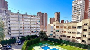A residential area with a swimming pool surrounded by well-maintained lawns and tall buildings. - DON Paco 5B in Benidorm (Benidorm)