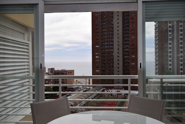 A balcony with a view of a train station and high-rise buildings. - Caballos 8E Estudio (Benidorm)