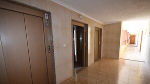 A hallway with elevators and a door leading to another room. - Acuarium 3 2F Estudio (Benidorm)