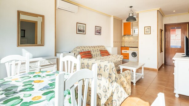 A room with a bed, a desk, a chair, a washing machine, and a mirror. - Acuarium 3 2F Estudio (Benidorm)