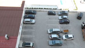 Eine Vogelperspektive auf einen Parkplatz mit mehreren in Reihen stehenden Autos.