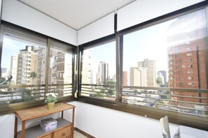A corner room with large windows, a small wooden table with a vase, and a box on a shelf. - Gemelos 5 4C in Benidorm (Benidorm)