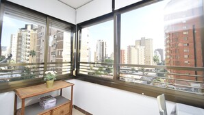 A corner room with large windows, a small wooden table with a vase, and a box on a shelf. - Gemelos 5 4C in Benidorm (Benidorm)