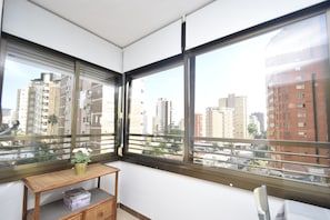A corner room with large windows, a small wooden table with a vase, and a box on a shelf. - Gemelos 5 4C in Benidorm (Benidorm)