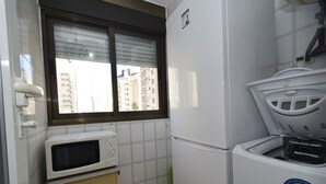 A compact kitchen with a microwave, a refrigerator, and a washing machine. - Gemelos 5 4C in Benidorm (Benidorm)