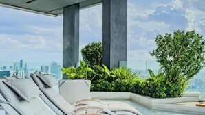A rooftop pool area with lounge chairs and greenery. - Bangkok Luxury New Condo · Siam Paragon · Walk to BTS (Bangkok)