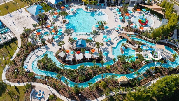 An aerial view of a resort with multiple swimming pools, water slides, and lounge areas surrounded by palm trees. - 10br Villa w/ Star Wars Theater & Game Room (Davenport)