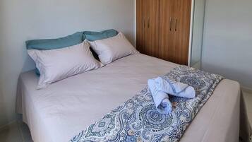 A bedroom with a bed, a wardrobe, and a ceiling light.