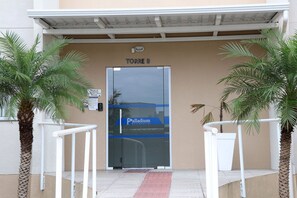 A building entrance with a sign for 'TORRE B' and a 'Palladium Residencia' sign. - Curta Praia do Quilombo - Palladium  (Penha)