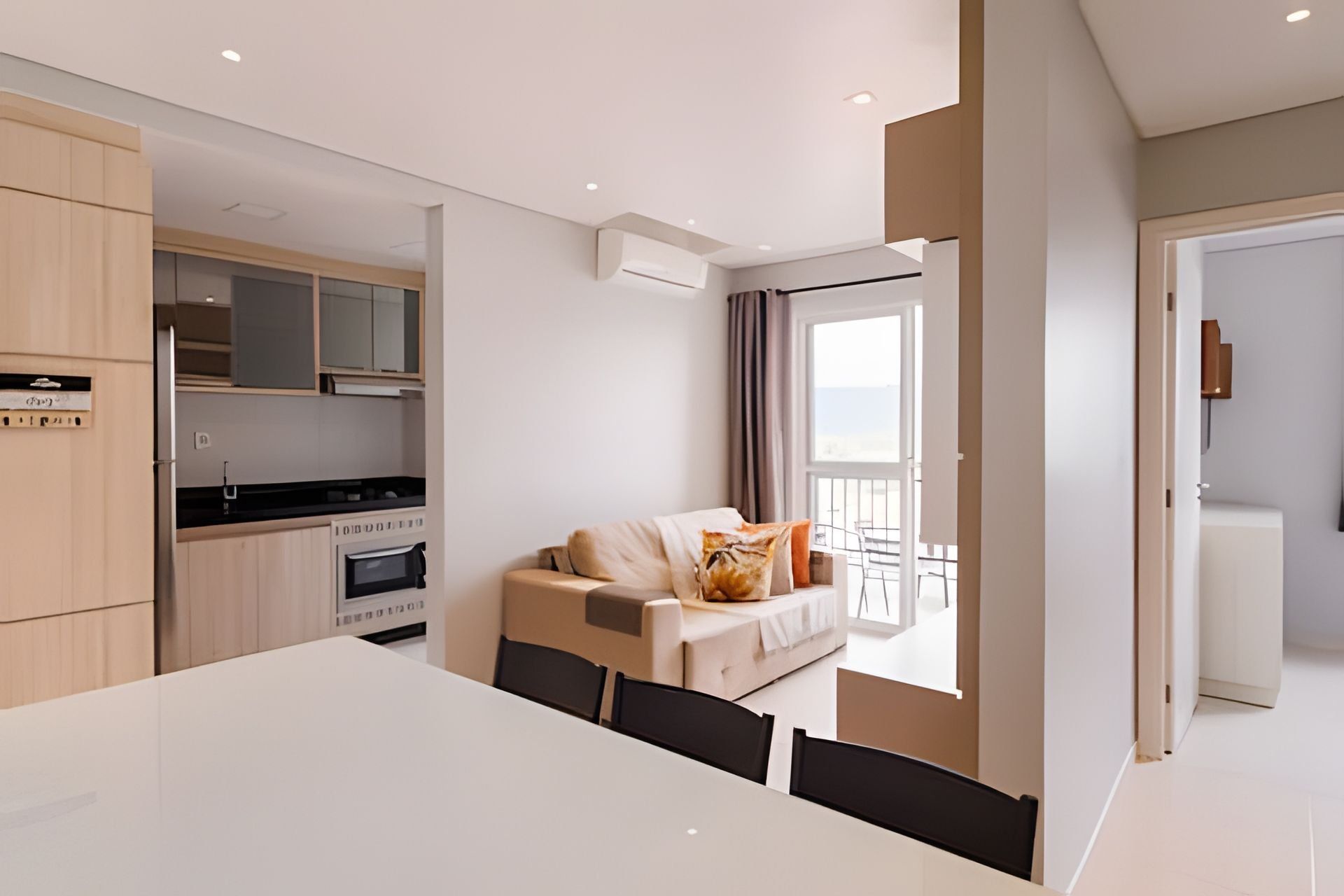 A modern apartment with a dining area, kitchenette, and a balcony with a view.