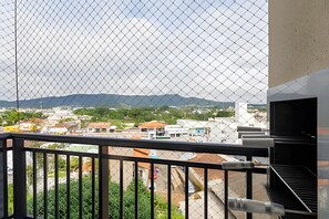 A balcony with a view of a cityscape, including buildings and mountains in the distance. - Curta Praia do Quilombo - Palladium (Penha)