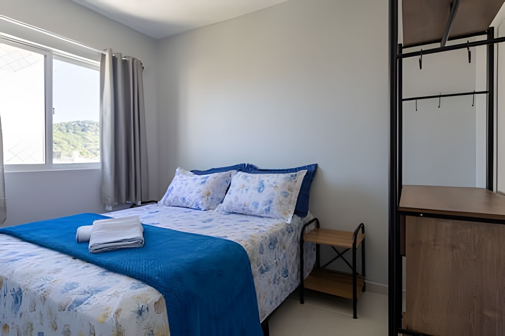 Un dormitorio con cama, un banco de madera y un escritorio con silla.