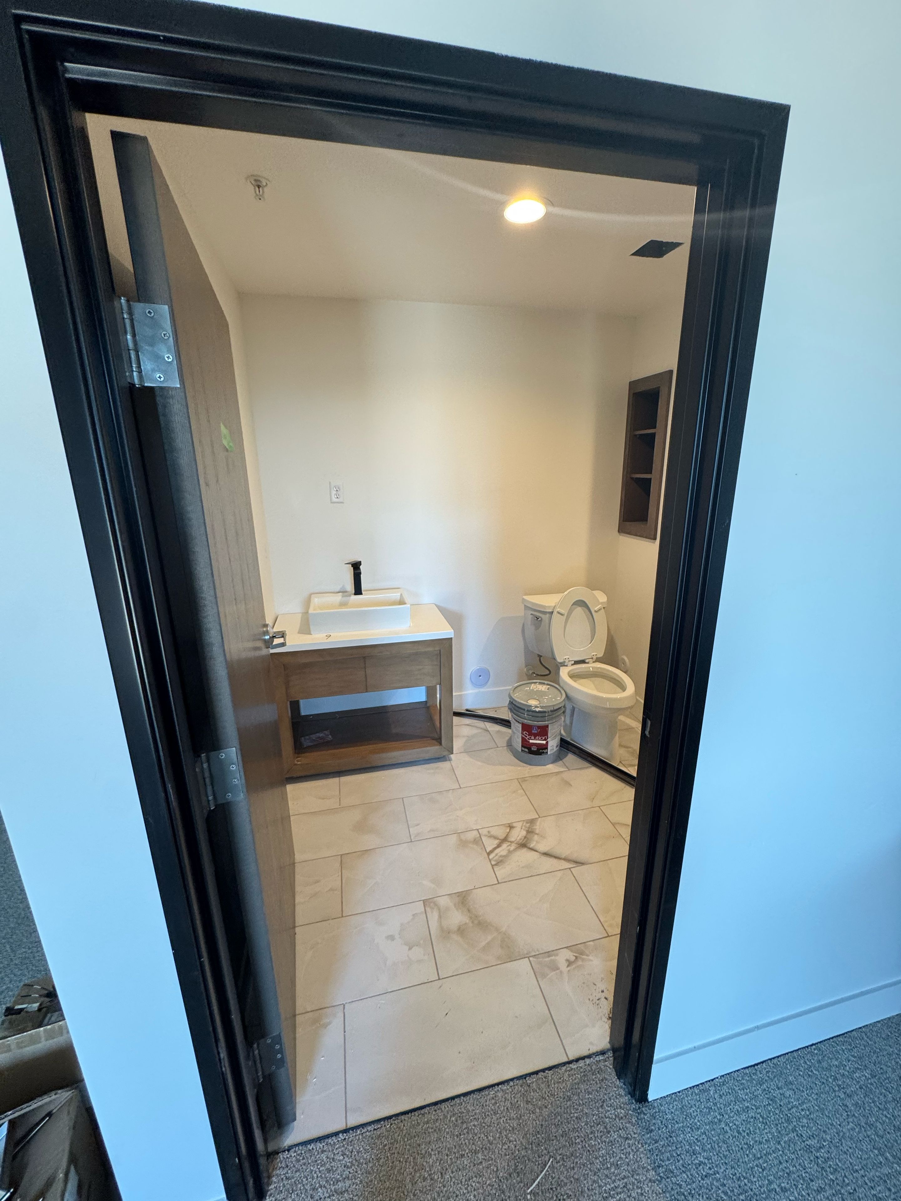 A bathroom with a toilet, sink, and shower area.