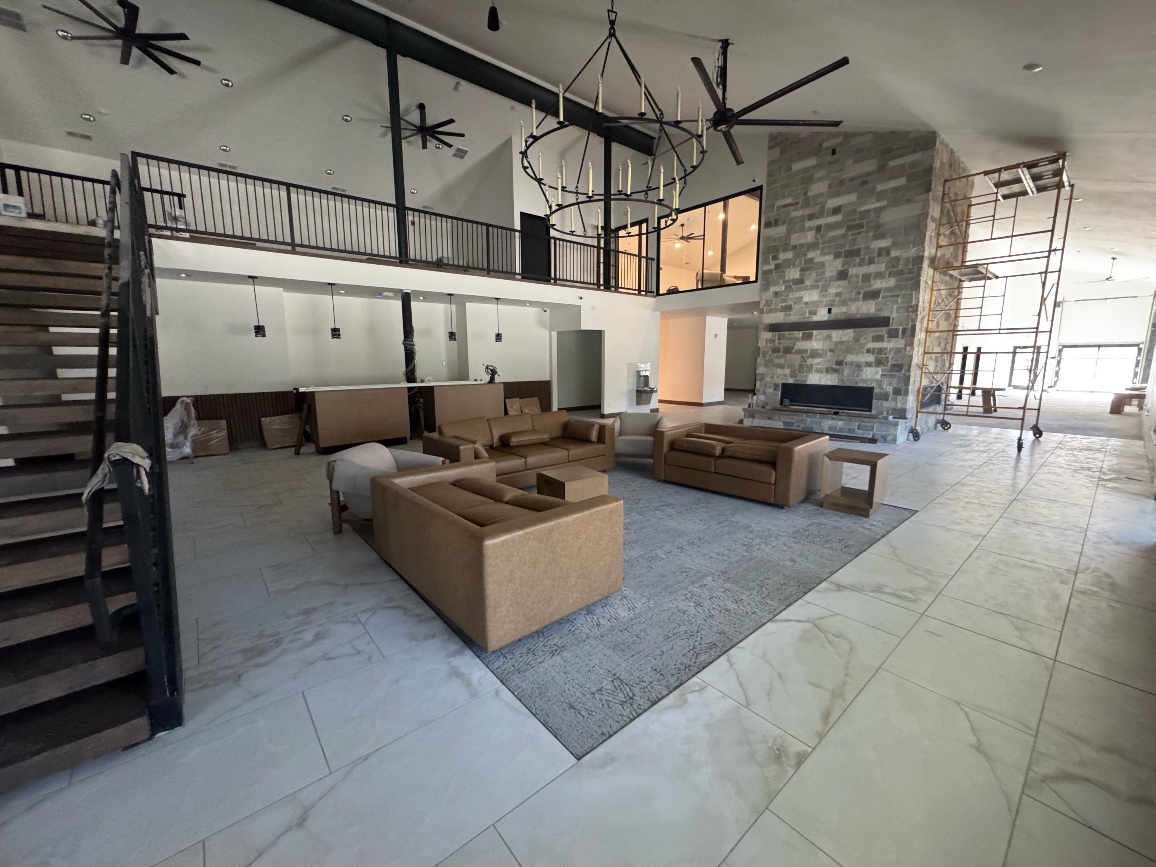 A spacious living area with high ceilings, a fireplace, and a mezzanine level.