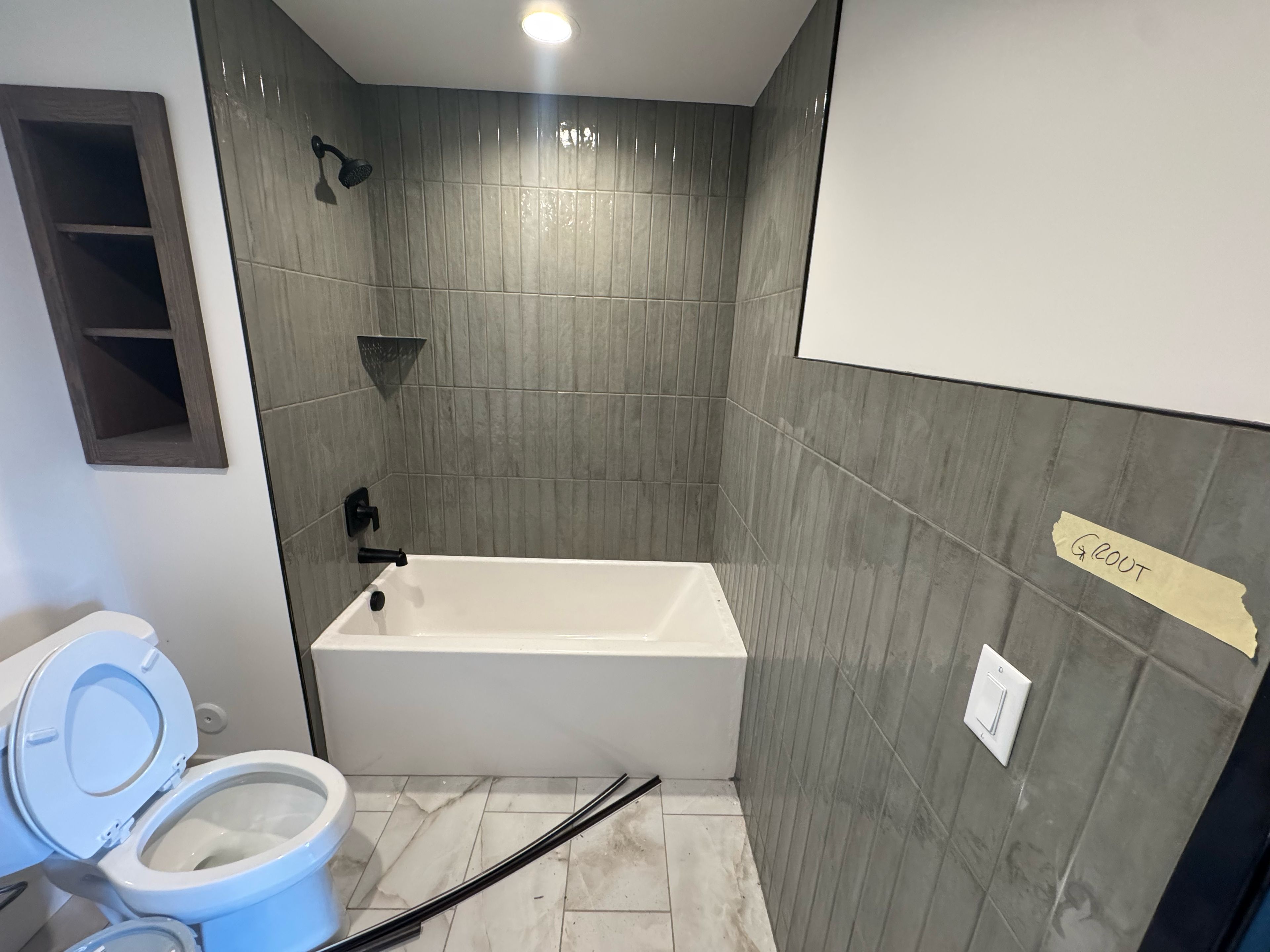 A bathroom with a bathtub, toilet, and shower.