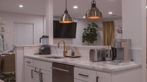 A modern kitchen with a central island, stainless steel appliances, and pendant lighting.