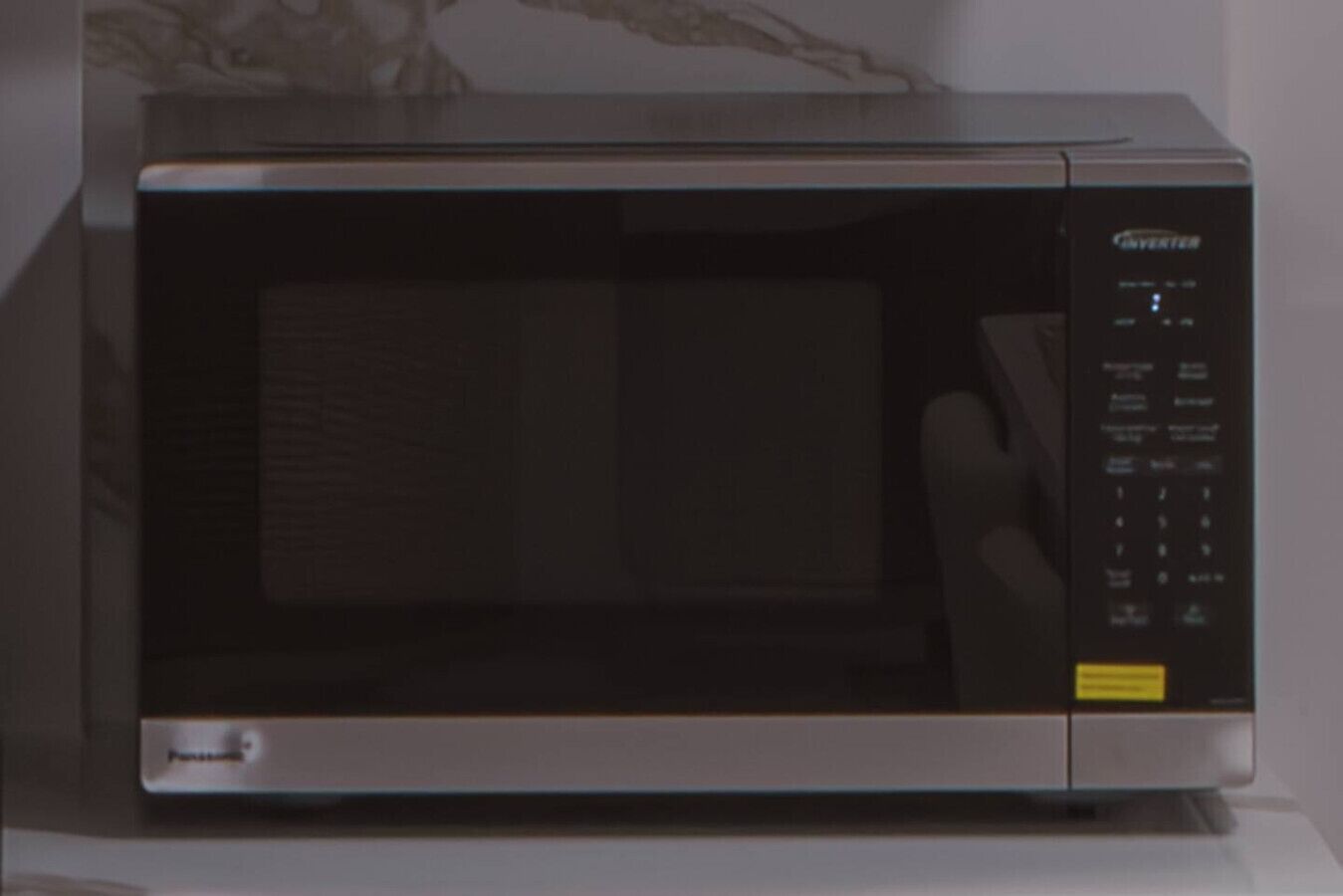 A stainless steel microwave oven with a digital control panel.