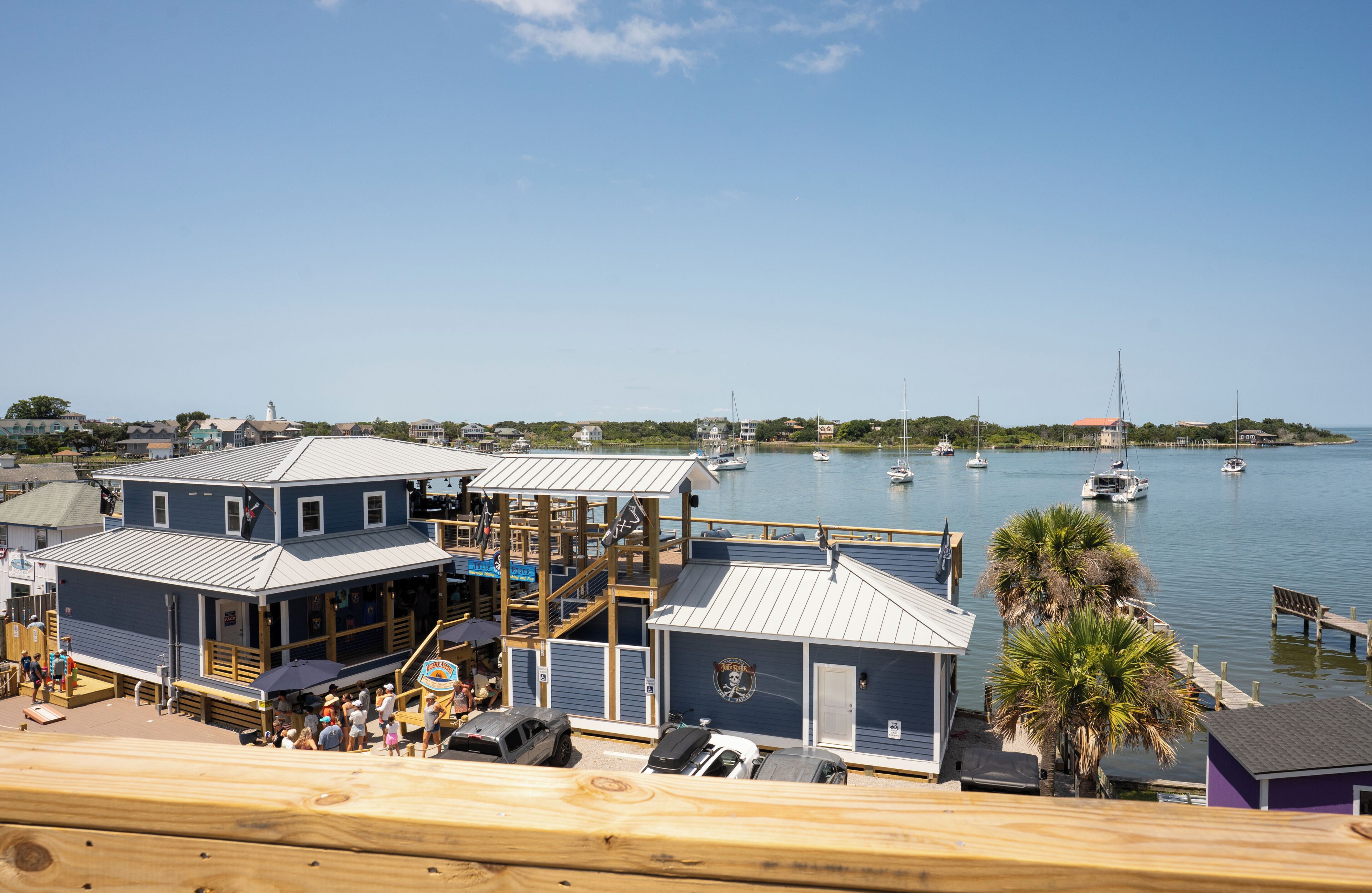 A waterfront property with multiple buildings, a dock, and boats.