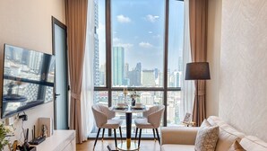 Ein modernes Wohnzimmer mit Blick auf die Stadt, einem Esstisch und einem Sofa.