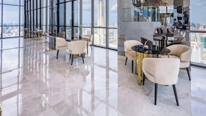 Eine geräumige, moderne Lounge mit hohen Decken und großen Fenstern, die einen Blick auf die Stadt ermöglichen.