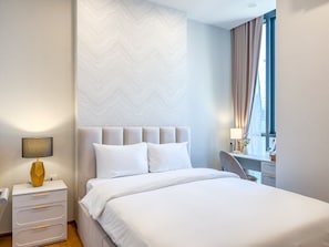 A hotel room with a bed, bedside table, lamp, and a view of the city through the window. - Central Bangkok New Condo · Walk to Siam Paragon (Bangkok)
