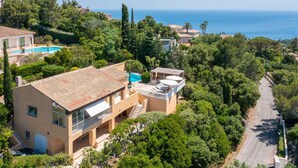 Villa d'estil mediterrani amb piscina, un balcó i vista al mar.