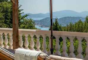 A balcony with a view of a coastal landscape, a wooden post, and a white balustrade. - Luxury sea view villa in Les Issambres | Villa Panorama Azur (Les Issambres)