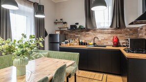 Eine moderne Küche mit einem Holzespeisetisch, schwarzen Schränken und einer Ziegelrückwand.