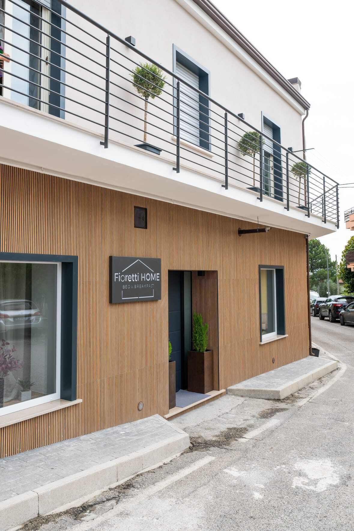 Un bâtiment moderne avec une enseigne indiquant « Fioretti HOME » et un balcon doté de balustrades.