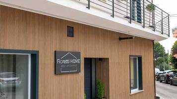 Un bâtiment moderne avec une enseigne indiquant « Fioretti HOME » et un balcon doté de balustrades.