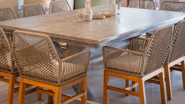 A dining area with a large wooden table, wicker chairs, and hanging wicker lamps. - Punta Mita 4BR Paradise | Golf Course Views (Punta Mita)