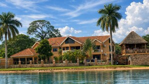 A resort with multiple buildings, a pool, and palm trees.