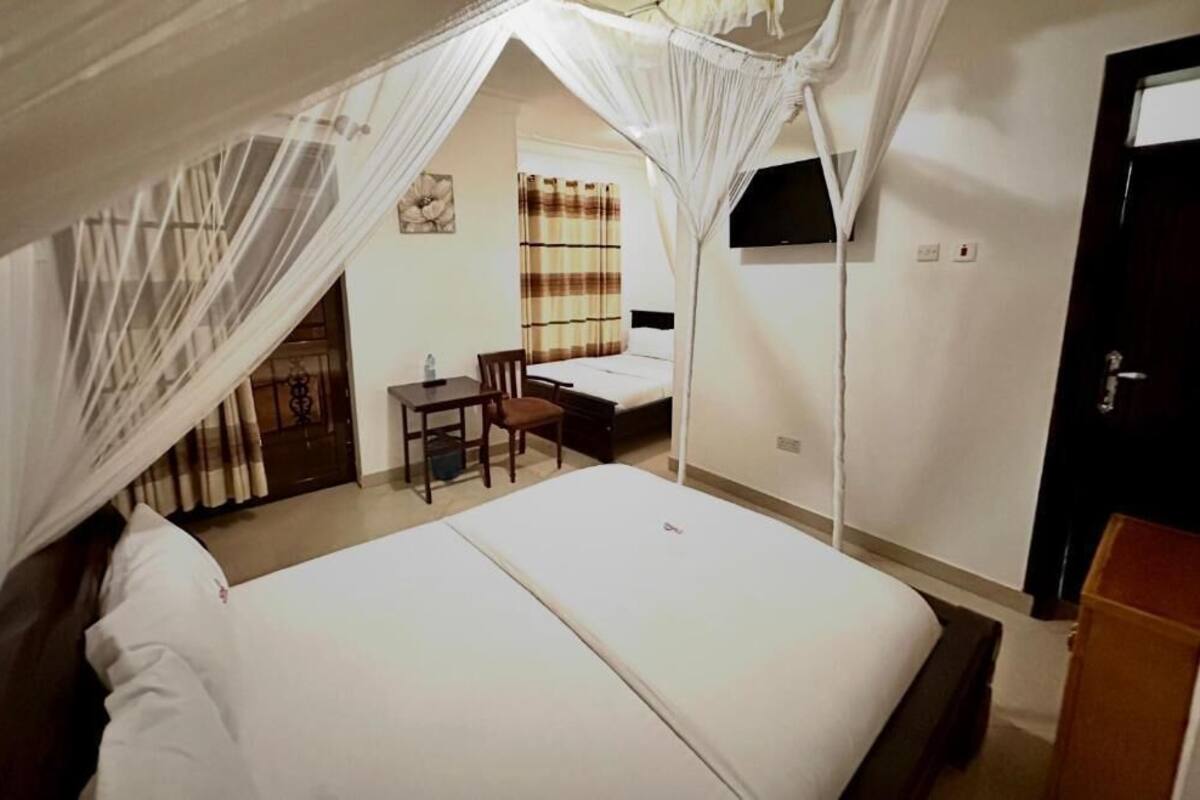 A bedroom with a bed, a desk, and a chair.