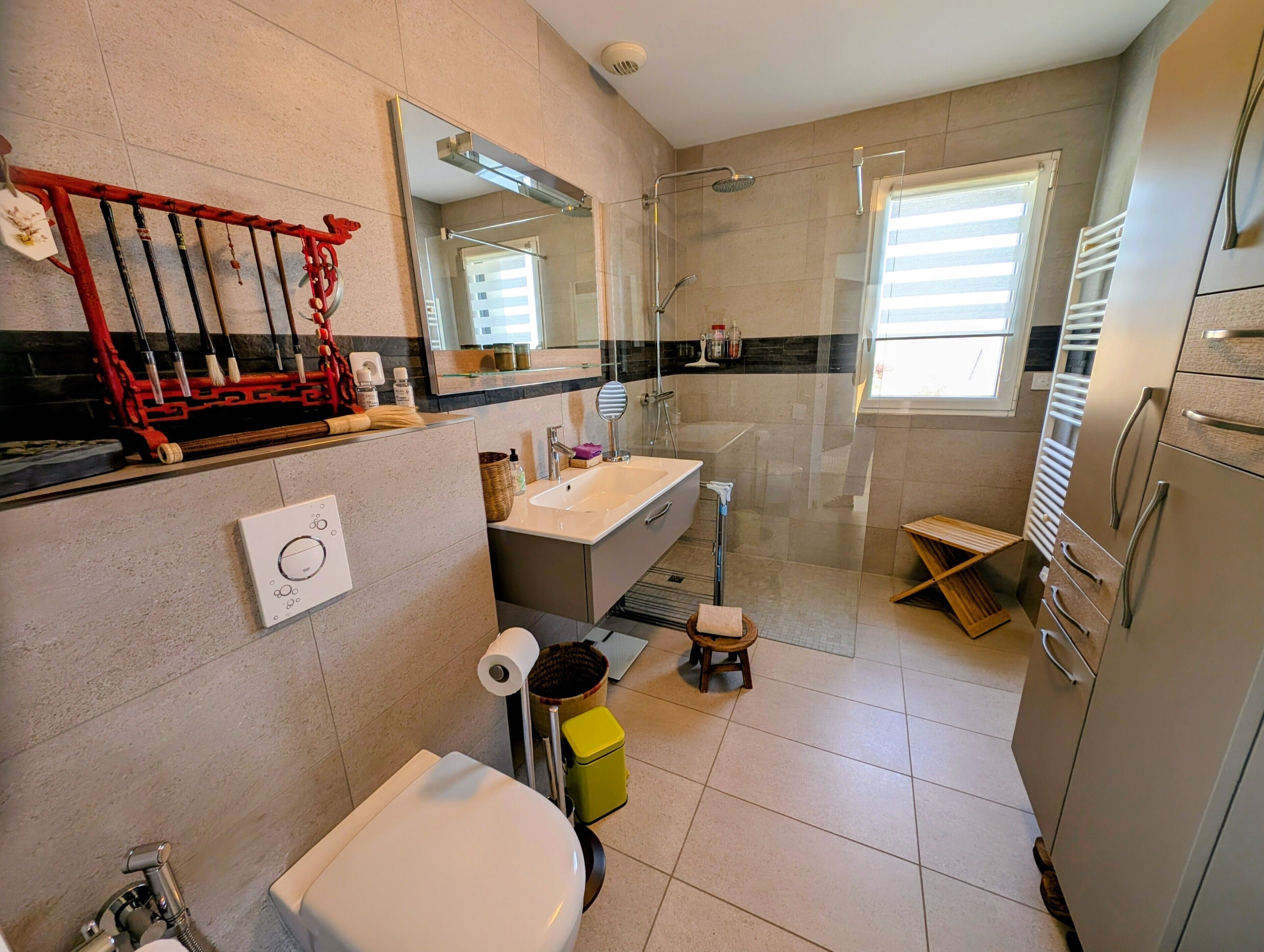 Une salle de bain moderne équipée de toilettes, d’un lavabo, d’une douche et d’un miroir.