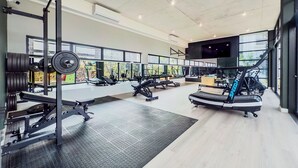 A gym with weightlifting equipment, treadmills, and exercise machines.