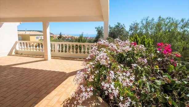 A covered outdoor area with a tiled floor, a white railing, and a view of the sea and distant buildings. - Villa 'Monte Lemos  35' with Sea View, Wi-Fi and Air Conditioning (Luz)