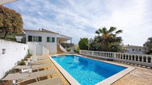 A swimming pool with lounge chairs, a white building with green shutters, and a white fence. - Villa 'Monte Lemos  35' with Sea View, Wi-Fi and Air Conditioning (Luz)