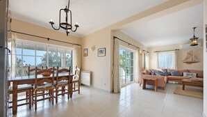A spacious living area with a dining table, chairs, a sofa, and a chandelier. - Villa 'Monte Lemos  35' with Sea View, Wi-Fi and Air Conditioning (Luz)