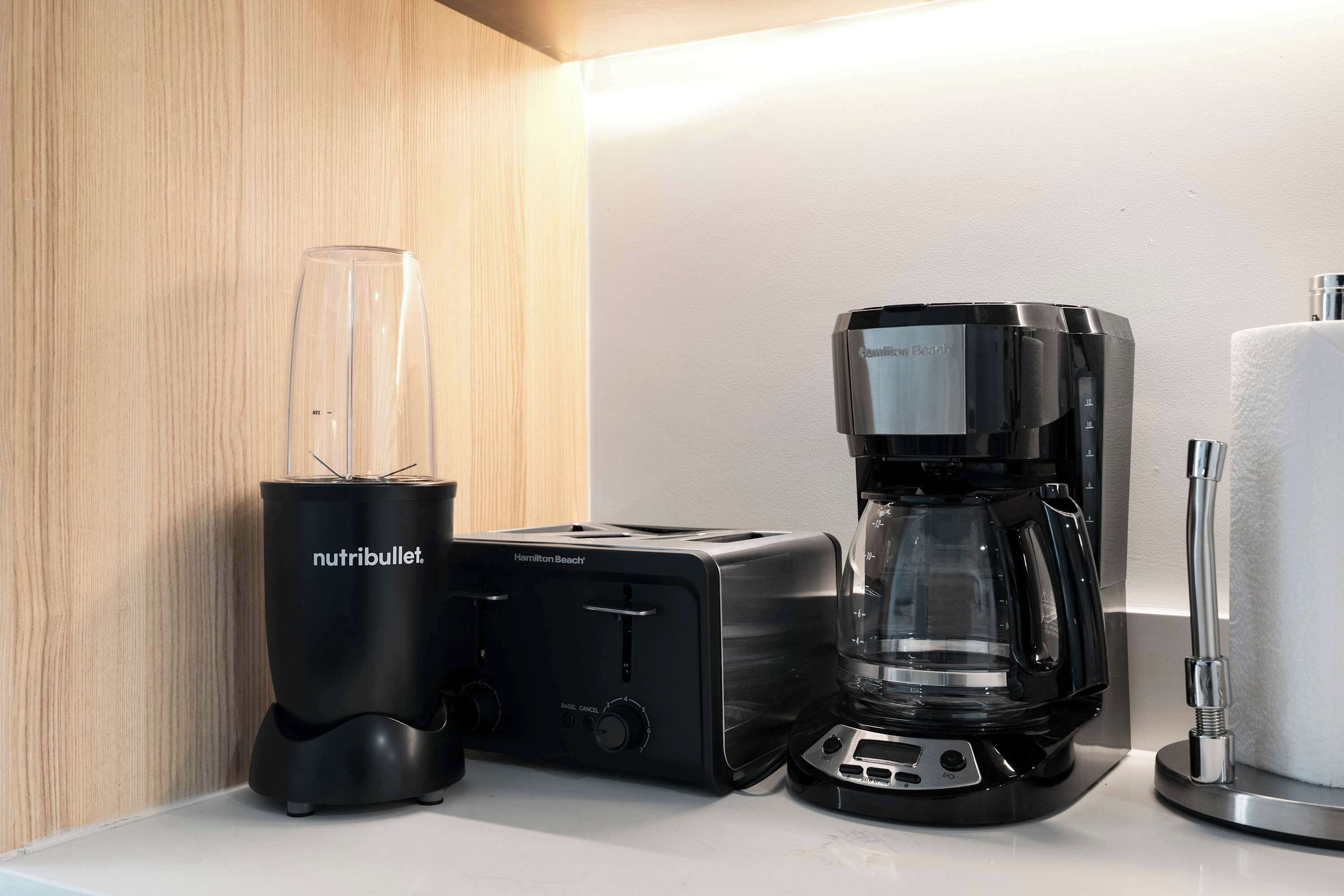 Une cuisine équipée d’un mixeur, d’un grille-pain et d’une machine à café, le tout posé sur un plan de travail.