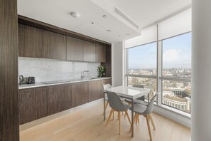 Une cuisine moderne avec un coin repas, de grandes fenêtres et une vue sur la ville.