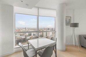 Une pièce moderne avec une grande fenêtre, une table et des chaises.