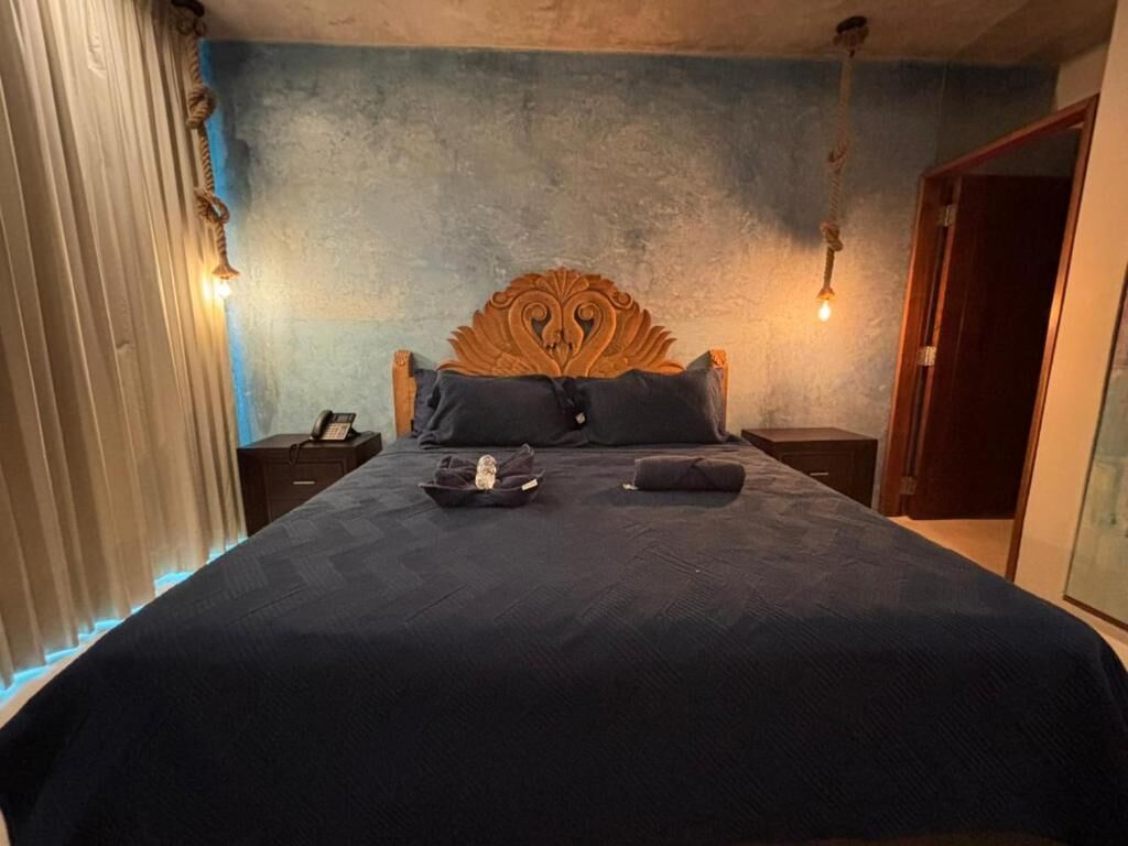 Ein Schlafzimmer mit einem großen Bett, einem Holzkopfstück, einem Nachttisch mit einer Lampe und einem Beistelltisch mit einem Telefon.