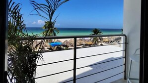 A balcony with a view of a beach, palm trees, and a clear blue sky. - Simple & Luxury (Progreso)