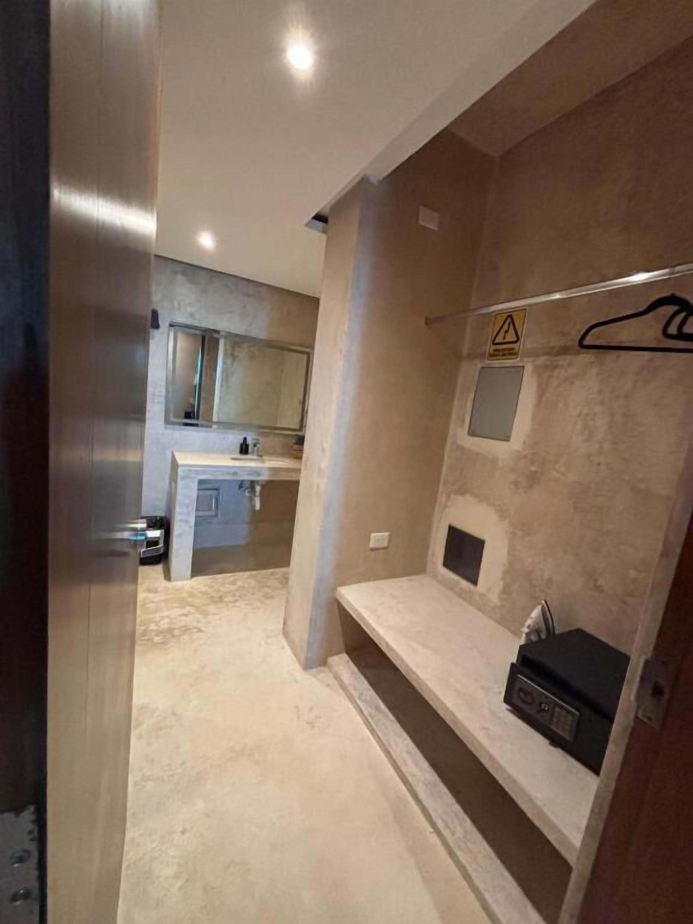 A modern bathroom with a shower, a vanity with a mirror, and a towel rack.