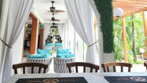 Un espace repas comprenant une table et des chaises, un ventilateur de plafond et un luminaire décoratif.