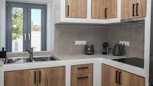 Una cucina moderna con mobili in legno, forno integrato e macchina da caffè.