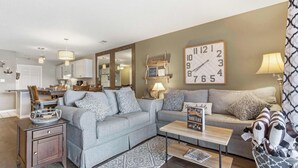 Ein Wohnzimmer mit einer Couch, einem Couchtisch und einer großen Wanduhr.