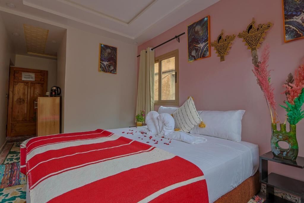 Un dormitorio con cama, un armario de madera, una ventana y decoración en la pared.