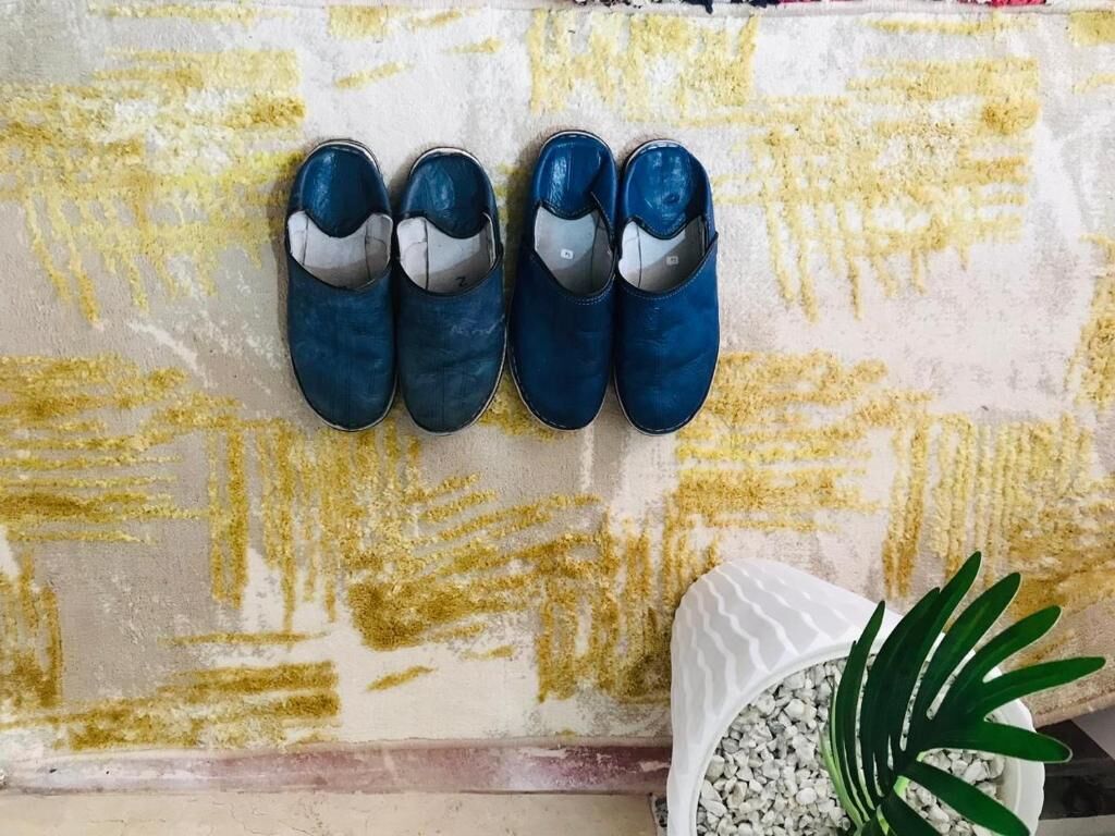 Une paire de chaussures bleues sur un mur à texture.
